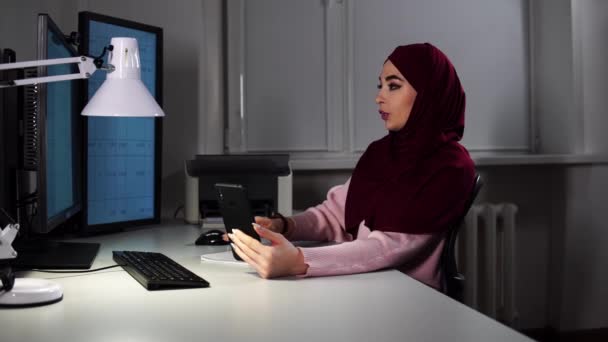 Женщина мусульманский офис менеджер говорит по видеокассетам и показывает документ с графиком после того, как распечатал его — стоковое видео