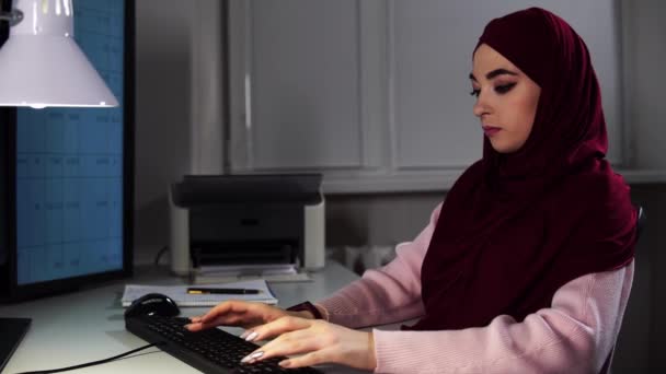 Femme gestionnaire dans hijab travaille à la saisie de bureau sur les arrêts de clavier et souriant — Video