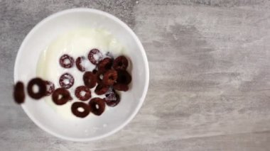 Çikolata aromalı mısır gevrekleri yukarıdan yavaş bir şekilde uçuyor.