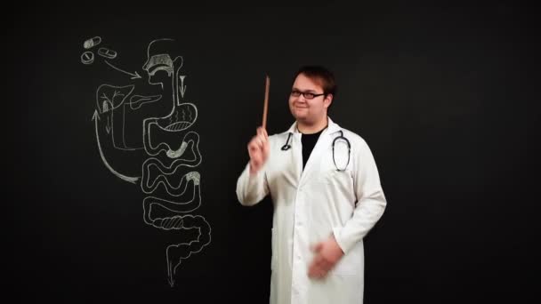 Arzt, der an der Tafel steht, erklärt, dass man Tabletten nehmen muss, wenn man Bauchschmerzen hat — Stockvideo