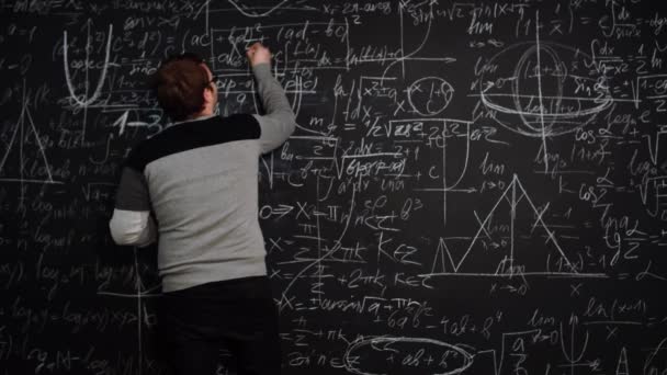 人在满是代数方程的黑板上写下公式，双手交叉地微笑着 — 图库视频影像