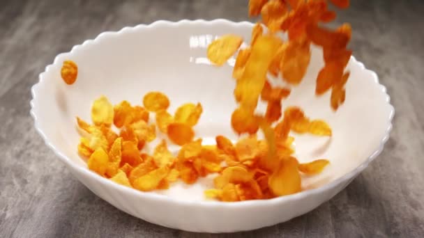 Koken fast food ontbijt van gele cornflakes in slow motion — Stockvideo