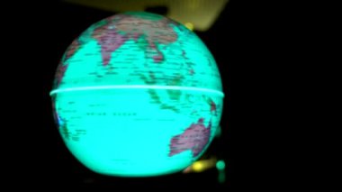 Aydınlatılmış küre kendi ekseni etrafında dönüyor ve yakın planda karanlıkta renk değiştiriyor.