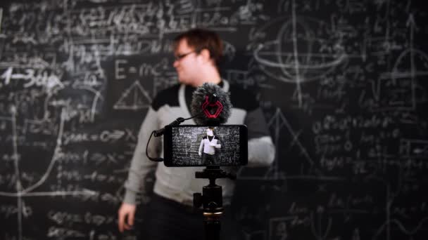 Professeur d'algèbre danse sur fond de tableau avec des formules et équation en face de la caméra mobile — Video