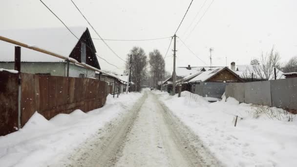 Krajina vesnice silnice v zimním období s padajícími sněhové vločky ve zpomaleném filmu — Stock video