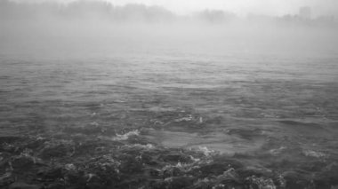 Kış zamanı, üzerinde bir sis olan sallanan nehrin görüntüsü yavaş çekimde çekilmiştir.