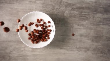 Bir tabak dolusu çikolatalı mısır gevreği yavaş çekimde yukarıdan düşen küçük toplar şeklinde.