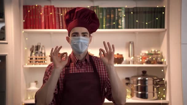 Blogueur alimentaire rend le contenu debout dans la cuisine dans un masque facial et parler de son futur plat — Video