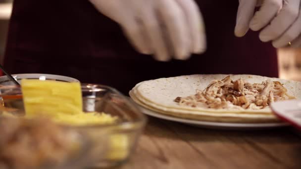 鶏とチーズのトルティーヤから伝統的なメキシコのエンチラーダを準備することのクローズアップ映像 — ストック動画