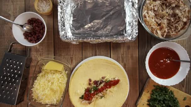 Stop de beweging van het koken traditionele mexicaanse enchilada op houten tafel gefilmd van boven — Stockvideo