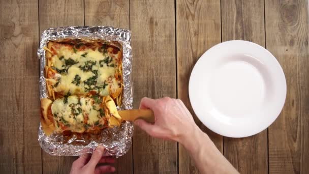 Casseruola ricoperta di carta stagnola con pronta enchilada gustosa e mani uomo mettendolo sul piatto — Video Stock