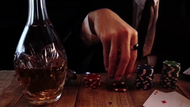 Rich man is sitting at poker table and waiting for his turn throwing chips in slow motion — Vídeo de Stock