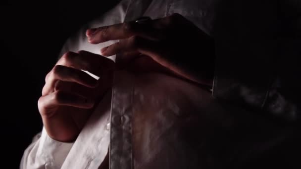 指輪とマニキュアを持つ男は下からマクロで撮影された白いシャツをボタンアップしています — ストック動画