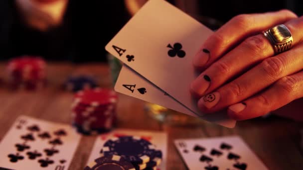 Macro footage of a hand with manicure holding two aces in process of playing poker — Wideo stockowe