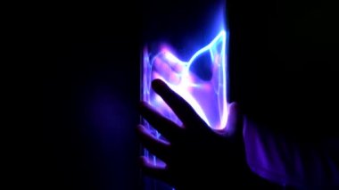 Çocuğun elinde iki eliyle bir Tesla tüpü var.