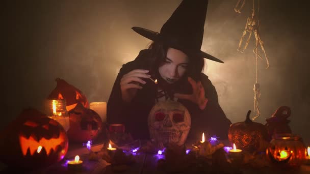 La femme à l'image de la sorcière évoque le crâne avec un bâton de joss et rit de façon inquiétante — Video