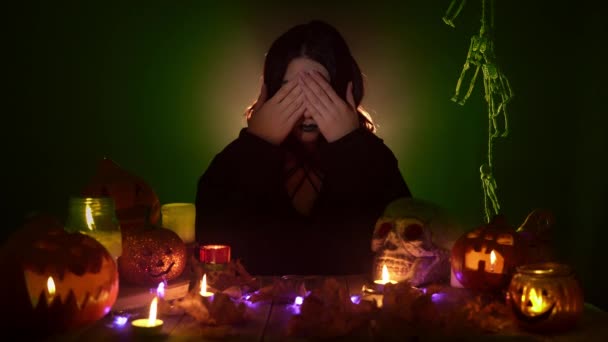 마녀가 할로윈 장식 사이에 앉아 눈을 감고 귀와 입을 벌리는 모습 — 비디오