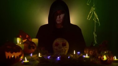 Siyah mantolu adam dik dik bakıyor ve korkunç bir şekilde gülümsüyor.