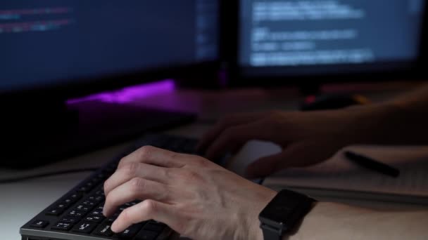 Fiatal programozó dolgozik számítógép előtt gépelés billentyűzeten és írás jegyzetek makró — Stock videók