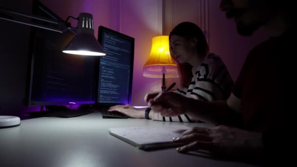 Два молодых кавказских программиста сидят перед компьютером и разрабатывают новое программное обеспечение — стоковое видео