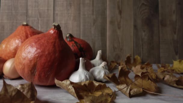 Nature morte avec des légumes d'automne et des feuilles d'érable sèches au ralenti sur fond de bois — Video