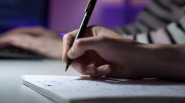 Bir erkeğin şemayı takip ettiği ve bir kadının arka planda klavyede daktilo yazdığı makro görüntüler.