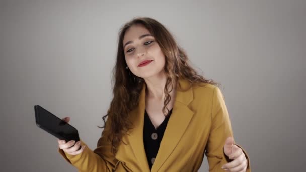 Isolated portrait of a young woman who dances and smiles listening to music in wireless earpods — Stock Video