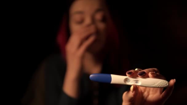 Macro filmagem de mulher mostrando teste de gravidez positivo e choro em segundo plano — Vídeo de Stock