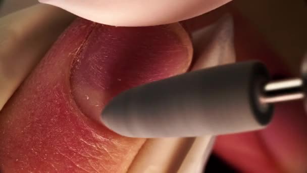 Master in gloves is polishing fingernails surface by electric file filmed in macro from above — Stock video