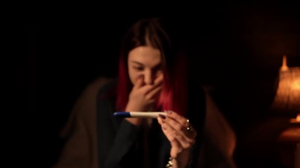 Portrait of a young woman surprised by positive result of pregnancy test and showing it — Stock video