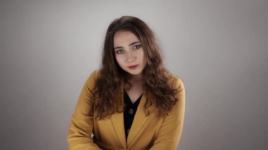 Smiling woman becomes suddenly unhappy and crosses hands after what she returns in positive mood
