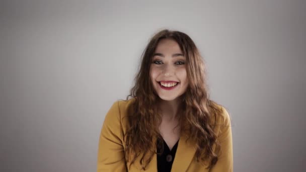 Kvinde stående på en hvid baggrund ryster på hovedet for at sige ja og smile i en langsom bevægelse – Stock-video