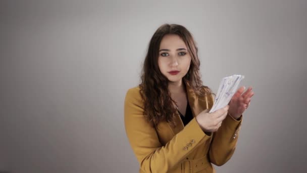 Junge Kaukasierin klatscht Geldgarbe an ihre Handfläche und wirft sie dann in die Luft — Stockvideo