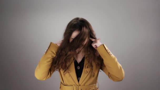 귀를 손가락으로 막고 머리를 천천히 흔들고 있는 여성의 고립된 초상화 — 비디오