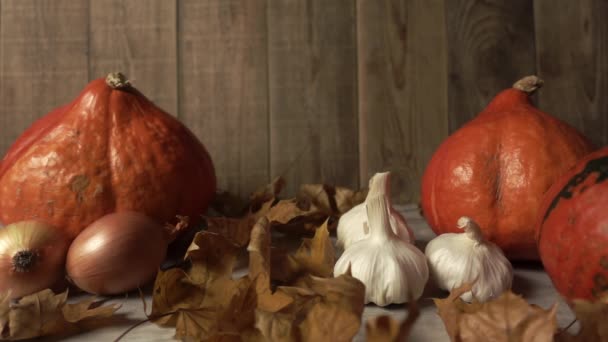 Still-life with autumn harvest and falling foliage in slowmo on wooden background — Stockvideo