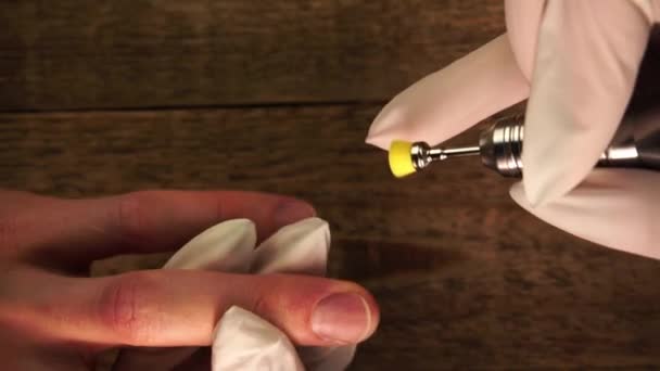 Closeup view of nail master removing dust from clients fingers by electric brush filmed from above — Αρχείο Βίντεο