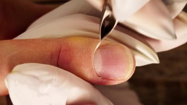 Macro view of removing cuticles by professional metal clippers in nail salon filmed from above — Stok video