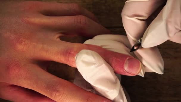 Makro-Ansicht der Maniküre-Verfahren, wo Meister in Schutzhandschuhen schneidet Nagelhaut durch Metallschere — Stockvideo