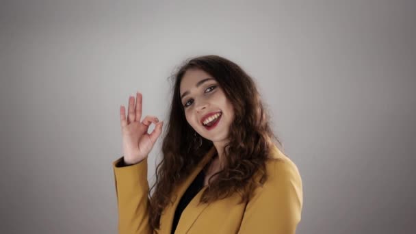 Mujer está mostrando ok signo y saludando la mano para decir adiós en slow mo sobre un fondo blanco — Vídeos de Stock