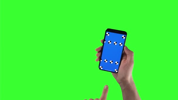 Man holds smartphone with tracking markers on display and swipes left then right on green screen — Vídeo de Stock