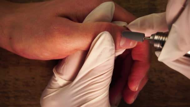 Vista de cerca de la manicura en guantes protectores usando un taladro de lima de uñas eléctrico para eliminar la cutícula — Vídeo de stock