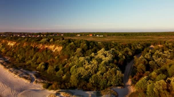 Tájkép a kis falu található egy zöld szikla mellett az óceán forgatott drón — Stock videók