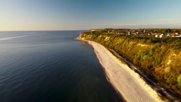 Paisaje de una cresta donde se encuentra la pequeña ciudad situada junto al océano azul se filma desde un dron — Vídeos de Stock