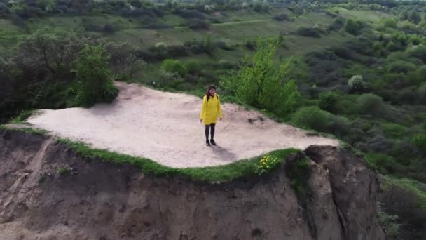 Frau steht am Rande eines Abgrunds am Berg und winkt mit der Hand und gibt Luftkuss — Stockvideo