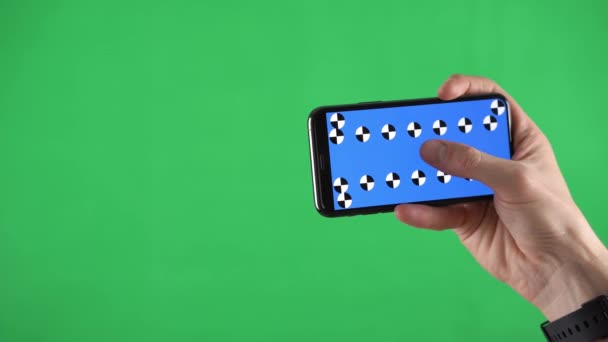 Close-up beelden van een smartphone in horizontale oriëntatie met tracking points en man glijdende pagina 's — Stockvideo