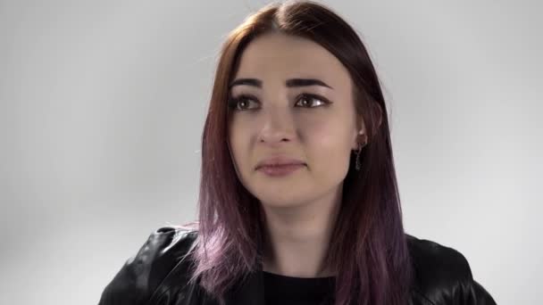 Portrait of young crying woman who tries to hold back her tears on white background — Stok Video