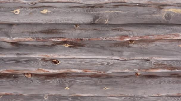 Detailní pohled na dřevěnou stěnu a létající sněhové vločky ve zpomaleném filmu — Stock video