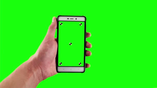 Homem detém smartphone antiquado com marcadores de rastreamento em exibição contra fundo de tela verde — Vídeo de Stock