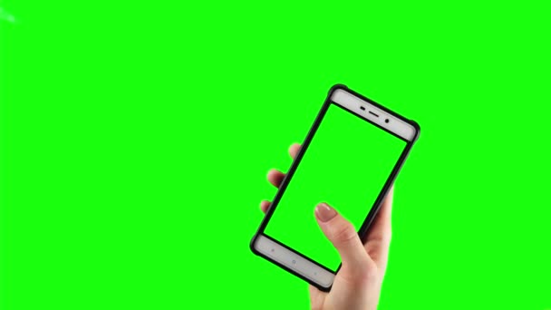 Woman holding old smartphone with green screen is swiping and tapping on it — ストック動画