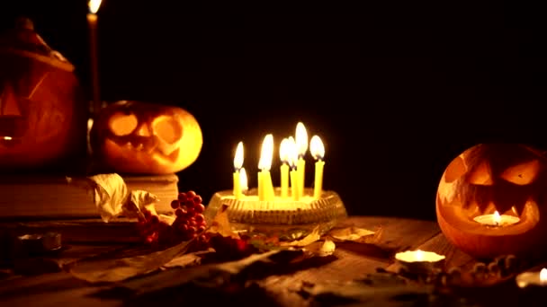 Pumpkin lanterns on Halloween decorations with candles and old books slider camera — Stock Video